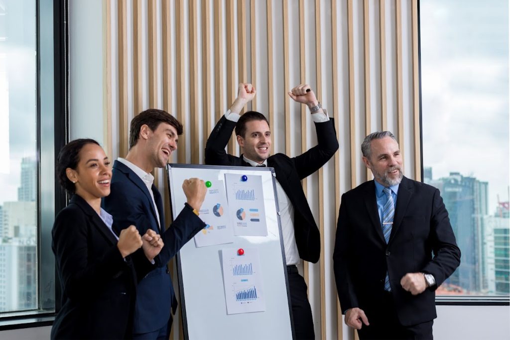 A diverse group of colleagues celebrating a successful brainstorming session in a modern office.