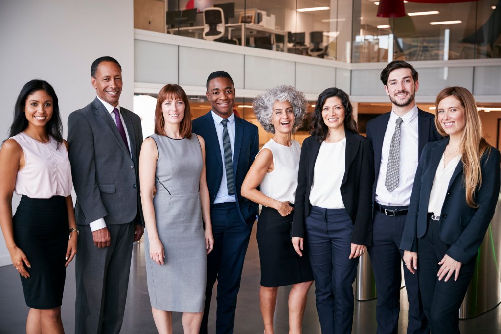 Diverse business team in formal attire standing in an office lobby