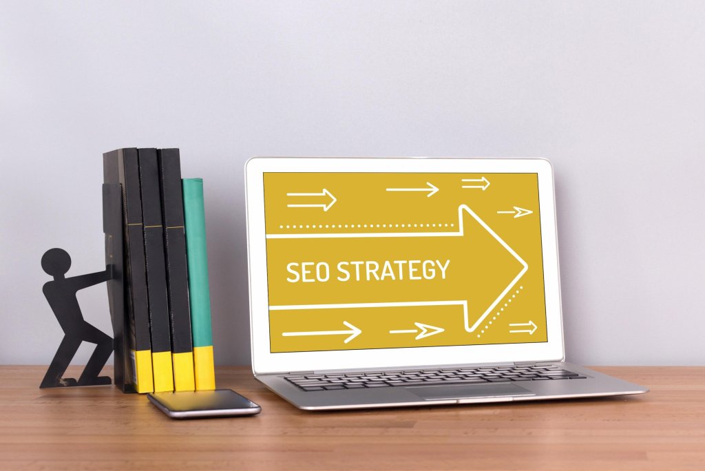 Figurine pushing books near laptop with SEO strategy