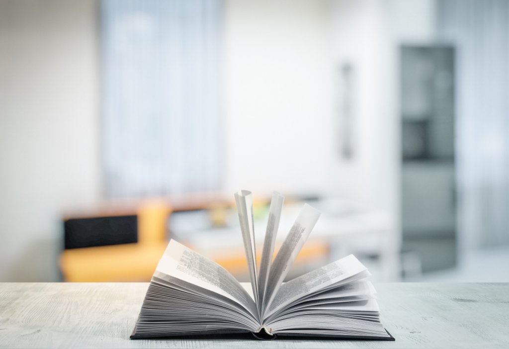 Open book flipping pages on wooden table