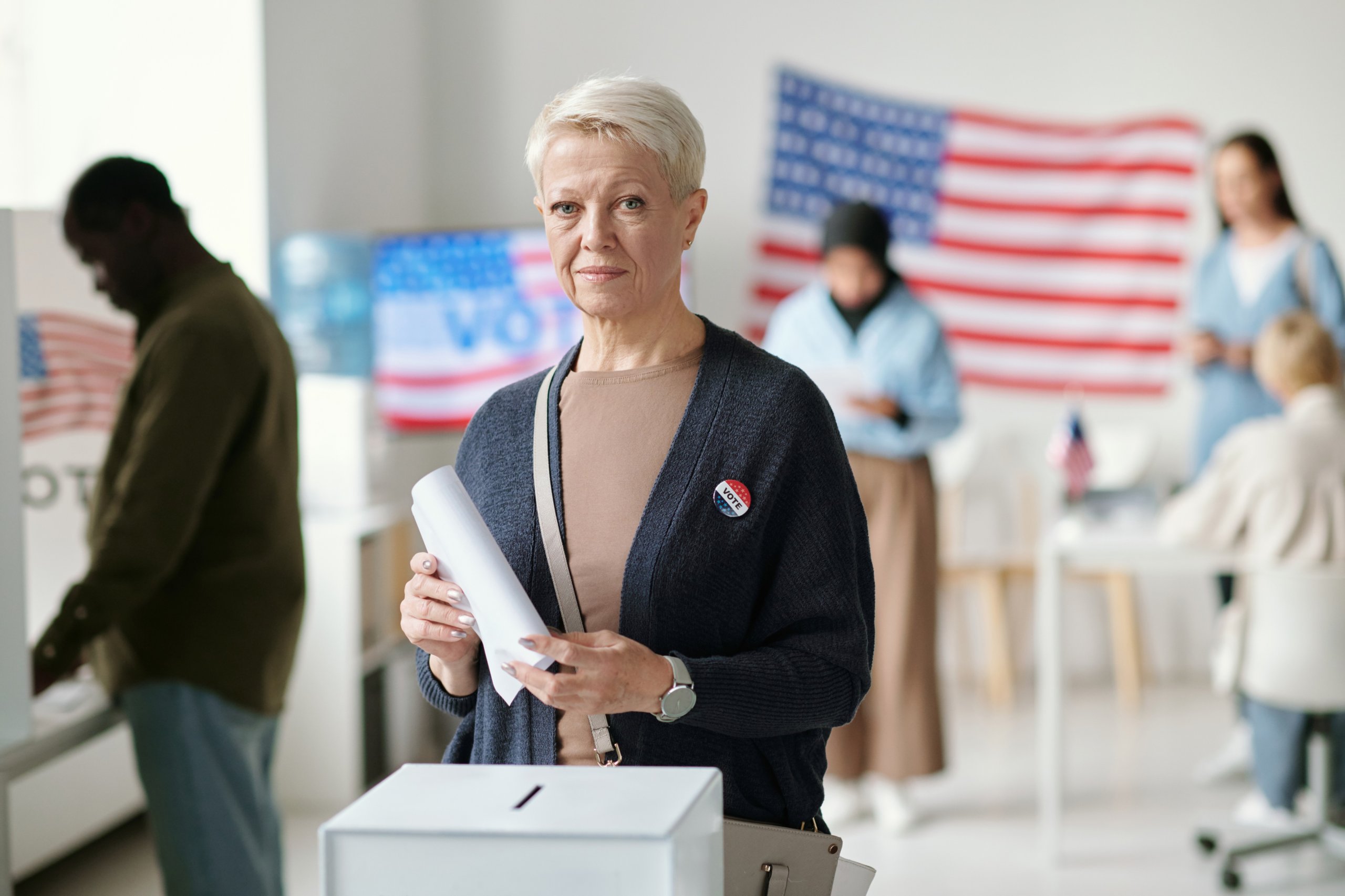Older woman casting ballot at voting station