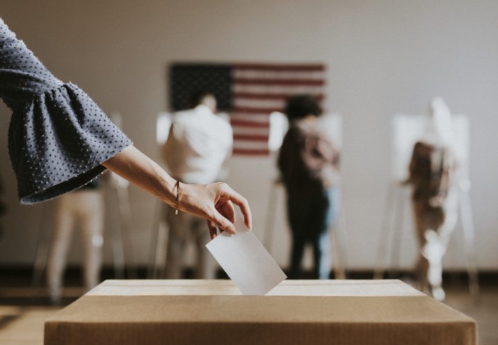 Hand dropping ballot into voting box